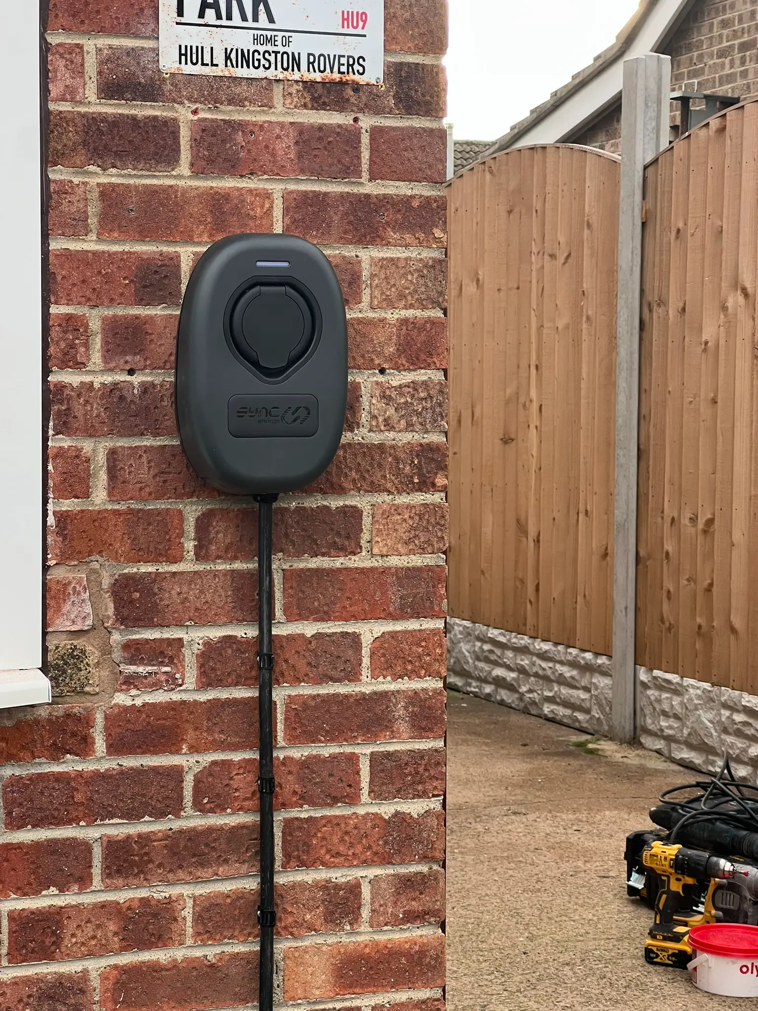 Completed SyncEnergy socketed EV charger mounted on the brick wall of a home in Hull