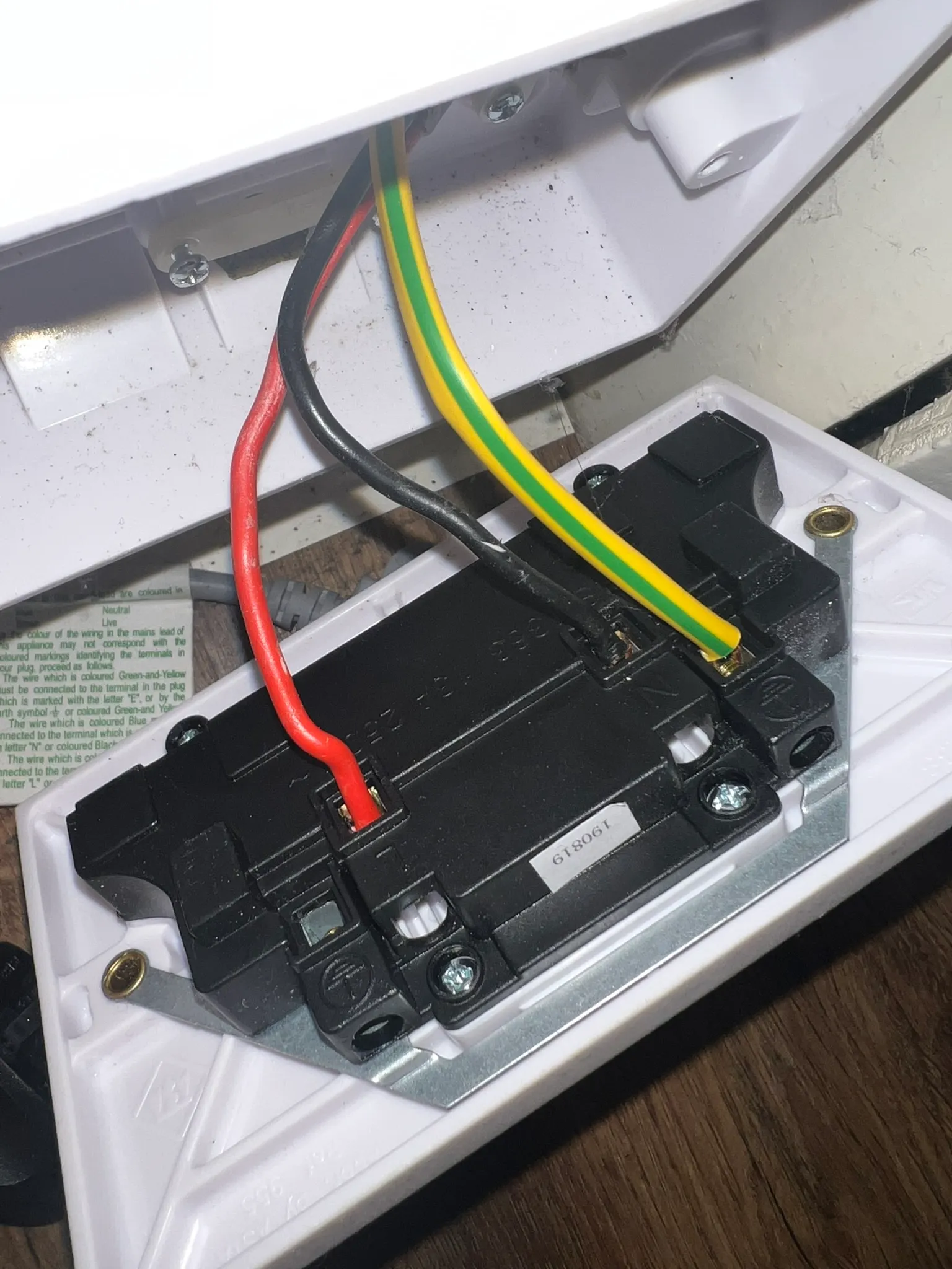 Back of the socket with the red conductor now in the L terminal and the black in N